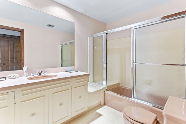 full bathroom featuring toilet, tile patterned floors, enclosed tub / shower combo, and vanity