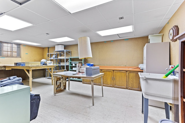 office space with a paneled ceiling and a workshop area