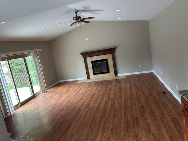 unfurnished living room with lofted ceiling, ceiling fan, dark wood-type flooring, a premium fireplace, and recessed lighting