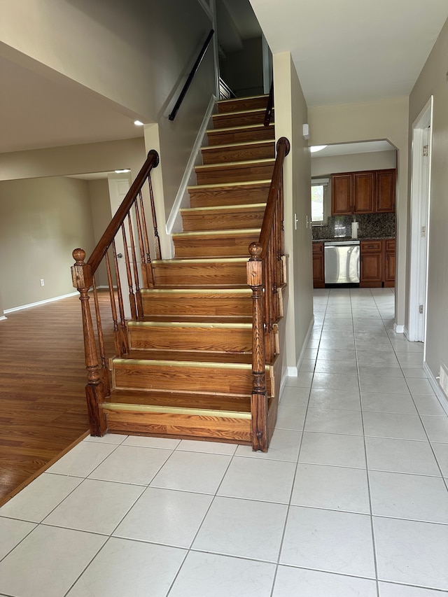 stairs with tile patterned flooring and baseboards