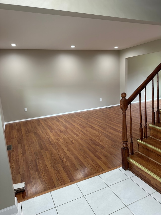 below grade area featuring recessed lighting, stairs, wood finished floors, and baseboards