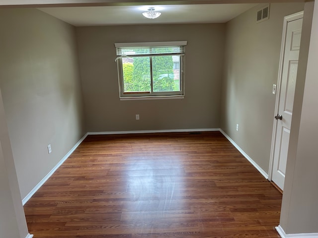 unfurnished room featuring dark wood-style flooring and baseboards
