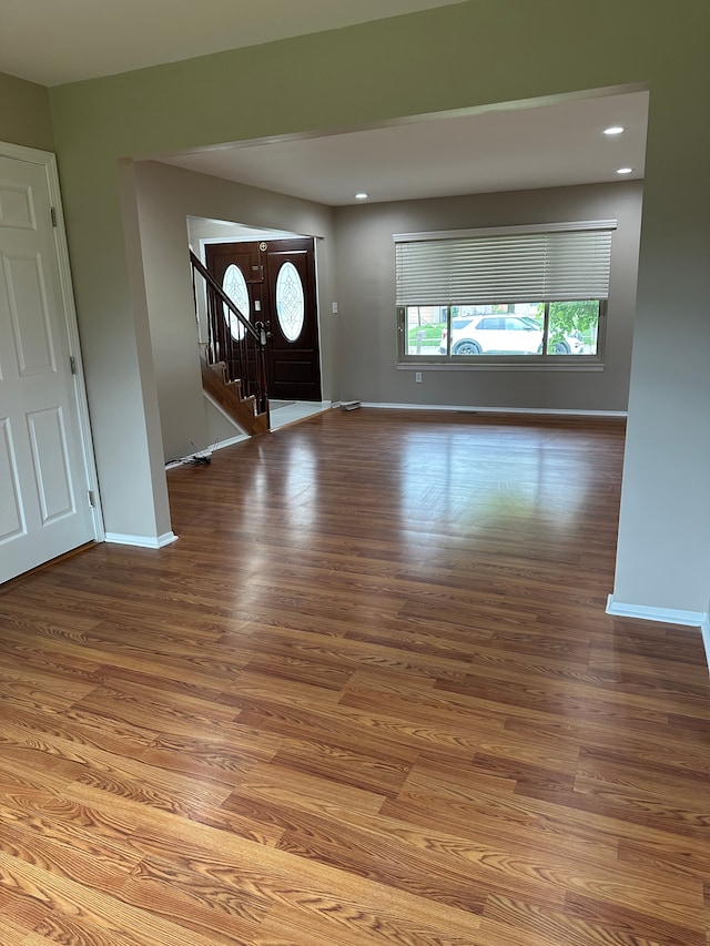 foyer featuring stairway, baseboards, wood finished floors, and recessed lighting