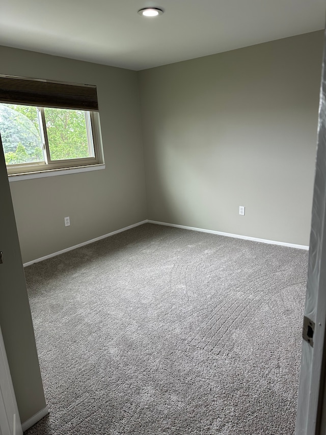 carpeted spare room with baseboards