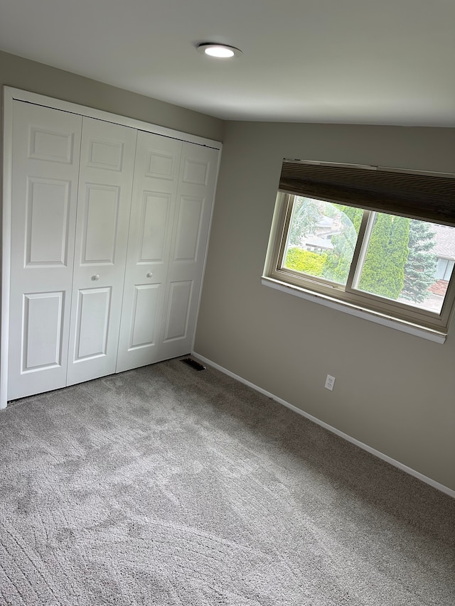 unfurnished bedroom with carpet flooring, a closet, and baseboards