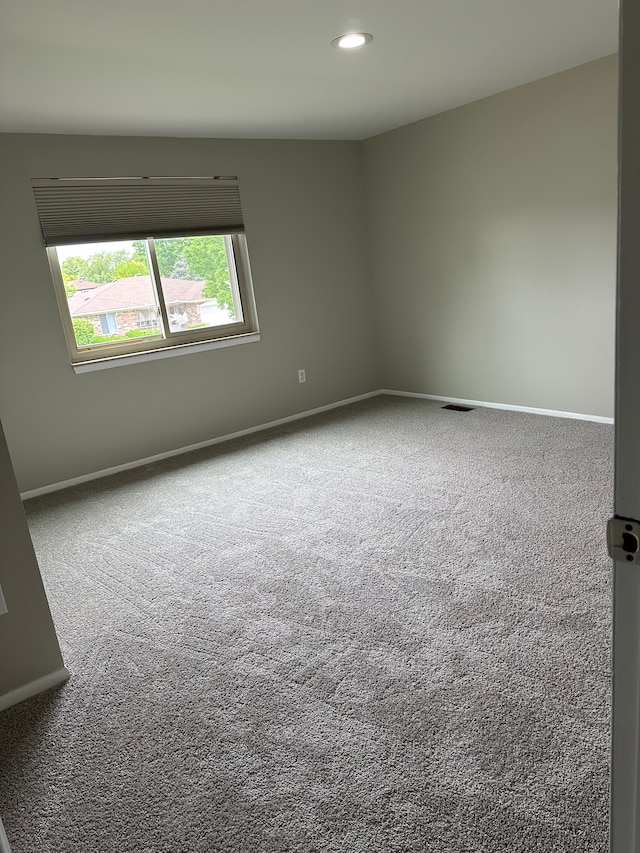 empty room with carpet floors, baseboards, and recessed lighting