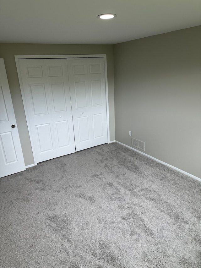 unfurnished bedroom featuring carpet, a closet, baseboards, and recessed lighting