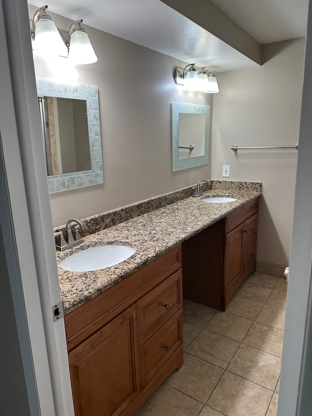 full bath featuring double vanity, tile patterned floors, and baseboards