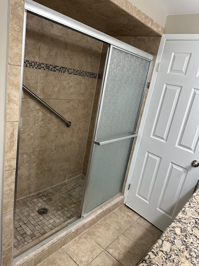 full bath featuring a shower stall and tile patterned floors