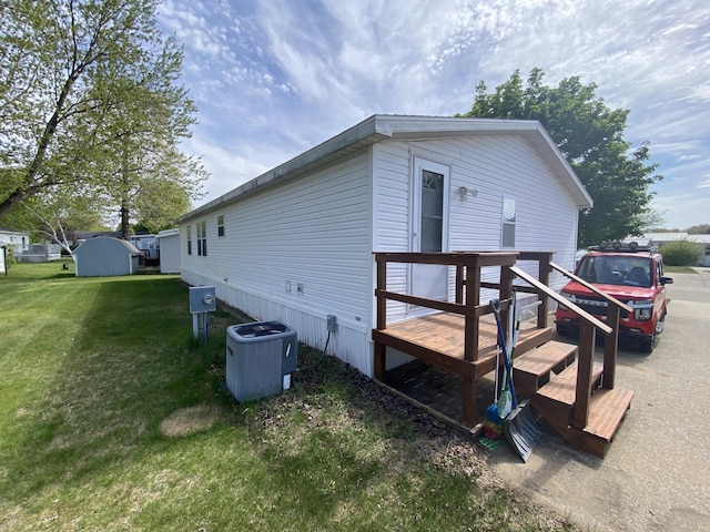 1966 Spyglass Trl, Muskegon, MI 49442 - view of property exterior with a lawn and central air condition unit