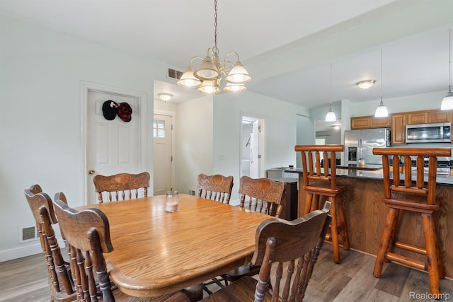 5160 N Milford Rd, Highland, MI 48356 - dining area featuring light wood-type flooring, a chandelier, and baseboards