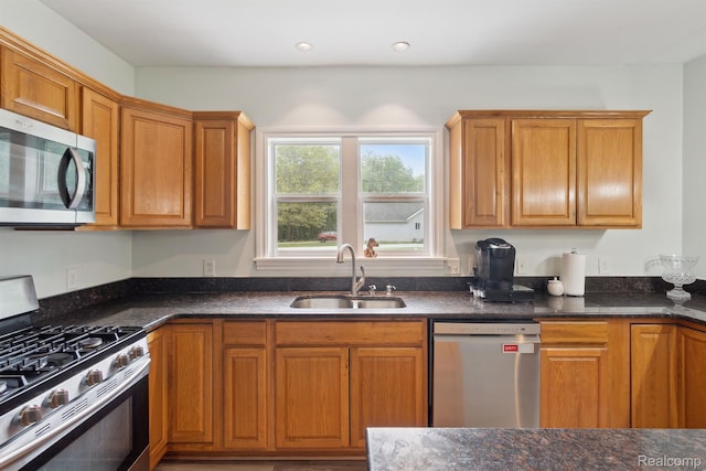 5160 N Milford Rd, Highland, MI 48356 - kitchen featuring stainless steel appliances, a sink, brown cabinetry, and dark stone countertops