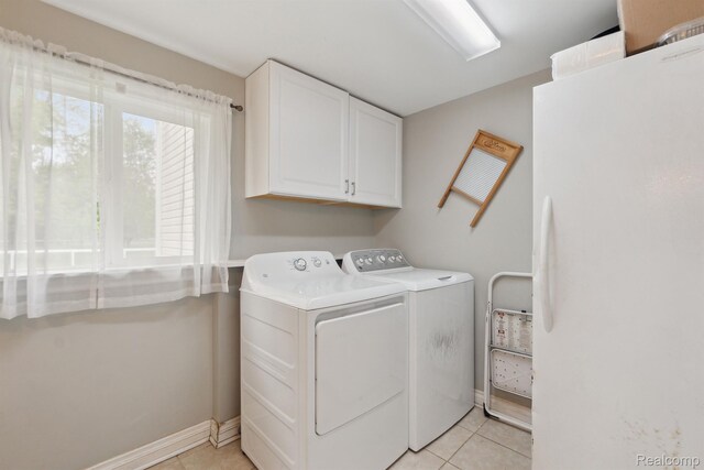 5160 N Milford Rd, Highland, MI 48356 - laundry area featuring cabinet space, washer and dryer, light tile patterned flooring, and baseboards