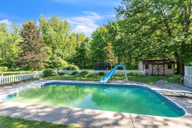 65505 M 43, Bangor, MI 49013 - view of swimming pool with a water slide, a storage unit, a fenced backyard, and an outbuilding