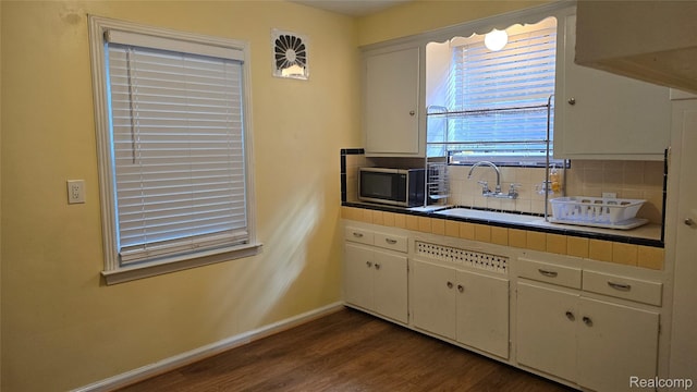 11356 Balfour Rd, Detroit, MI 48224 - kitchen with tile countertops, a sink, decorative backsplash, dark wood-type flooring, and stainless steel microwave