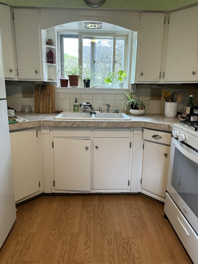 kitchen featuring white appliances, white cabinetry, and light wood-type flooring