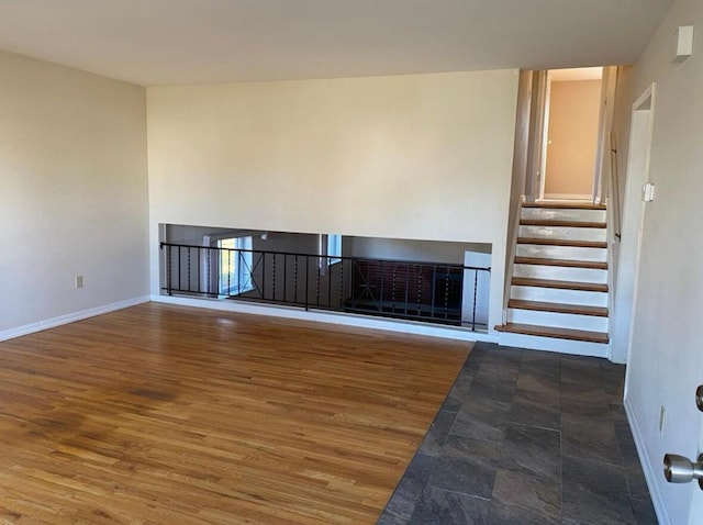 unfurnished living room with baseboards and wood finished floors