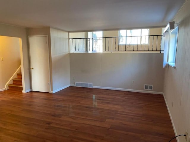 spare room with wood finished floors, stairs, and baseboards