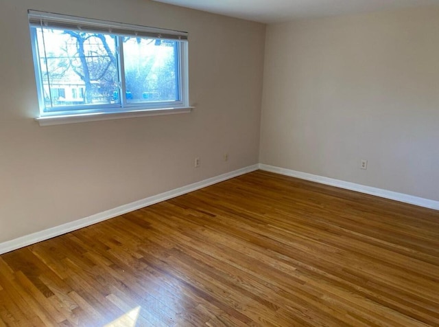 unfurnished room with baseboards and wood finished floors