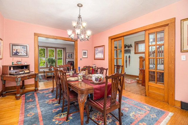 488 4th St, Manistee, MI 49660 - dining area with wood-type flooring, a chandelier, and baseboards