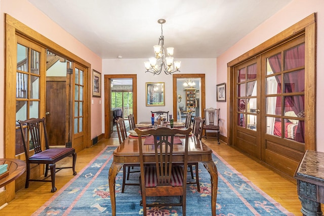 488 4th St, Manistee, MI 49660 - dining area featuring french doors, a chandelier, wood finished floors, and baseboards