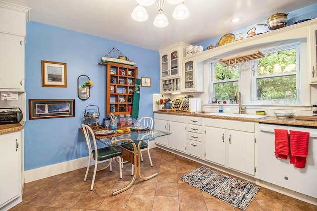 488 4th St, Manistee, MI 49660 - kitchen with a sink, a chandelier, white cabinetry, dishwasher, and glass insert cabinets