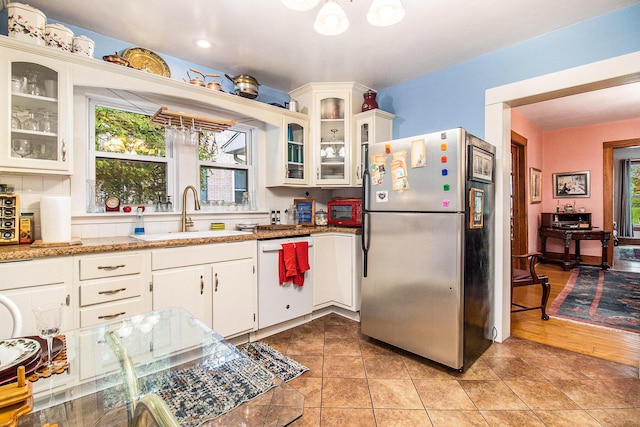 488 4th St, Manistee, MI 49660 - kitchen featuring freestanding refrigerator, a sink, white dishwasher, and plenty of natural light
