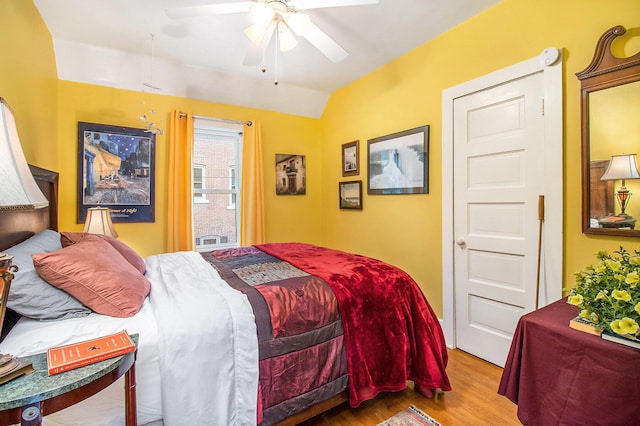 488 4th St, Manistee, MI 49660 - bedroom featuring wood finished floors, vaulted ceiling, and ceiling fan