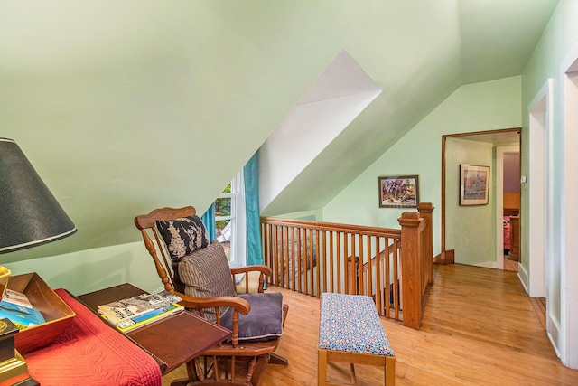 488 4th St, Manistee, MI 49660 - sitting room with lofted ceiling, light wood finished floors, and an upstairs landing