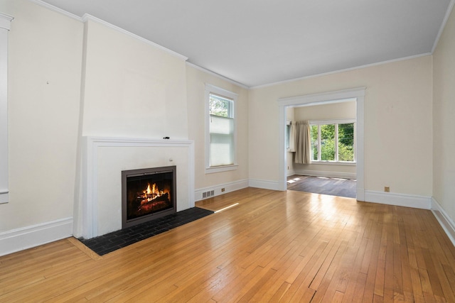 1054 Ferdon Rd, Ann Arbor, MI 48104 - unfurnished living room with hardwood / wood-style floors, a fireplace with flush hearth, crown molding, and baseboards