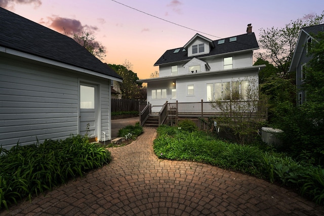 1054 Ferdon Rd, Ann Arbor, MI 48104 - view of front of house featuring a chimney, a deck, a patio, and cooling unit