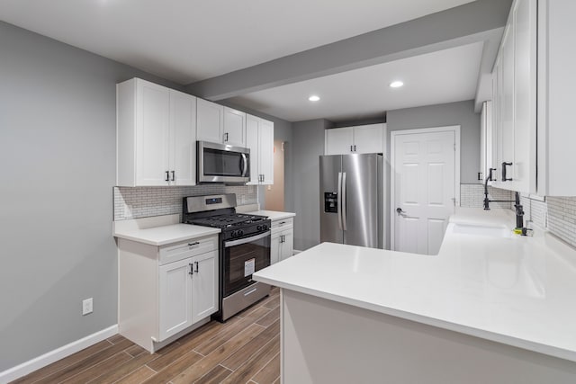 20172 Stotter St, Detroit, MI 48234 - kitchen featuring appliances with stainless steel finishes, a sink, backsplash, wood finished floors, and white cabinets