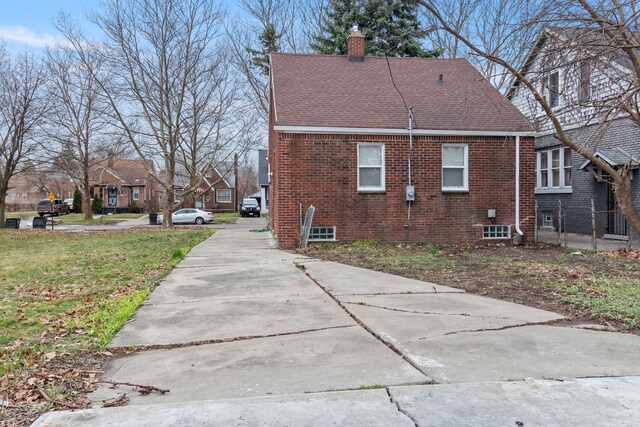 20172 Stotter St, Detroit, MI 48234 - view of property exterior featuring brick siding, a chimney, driveway, and roof with shingles