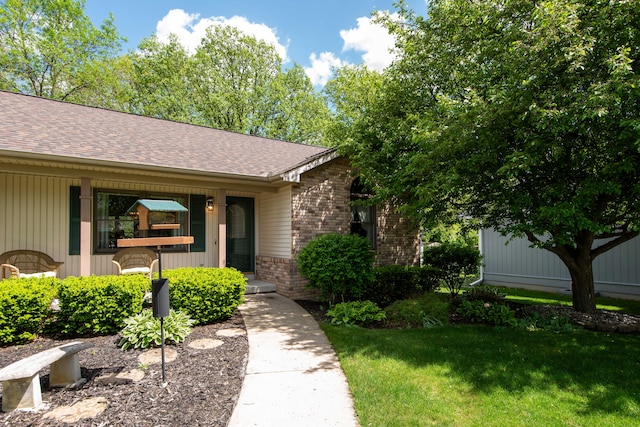 906 Village Dr, Davison, MI 48423 - view of front of home with a porch, a shingled roof, brick siding, and a front lawn