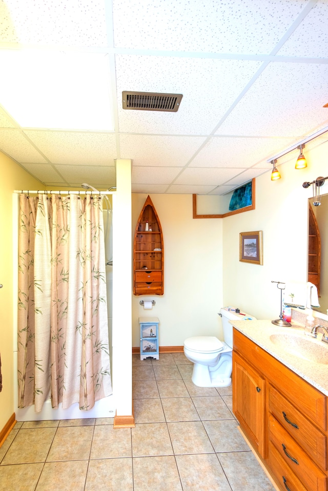 906 Village Dr, Davison, MI 48423 - bathroom featuring a paneled ceiling, toilet, tile patterned flooring, vanity, and curtained shower
