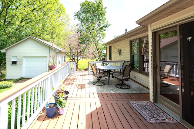 906 Village Dr, Davison, MI 48423 - wooden terrace with outdoor dining space, an outbuilding, and a detached garage