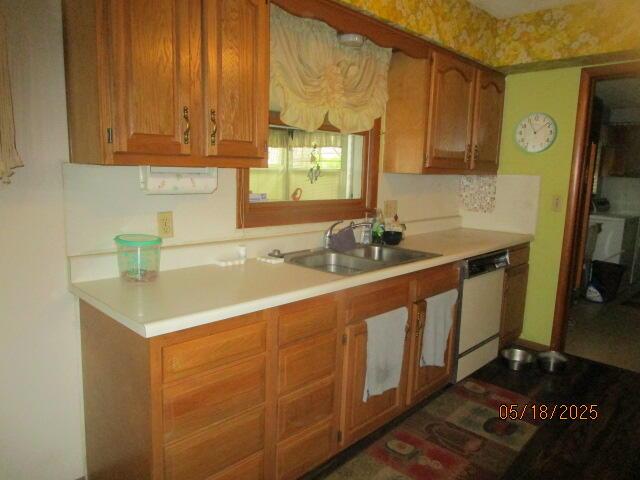 260 W Saint Joseph St, Coloma, MI 49038 - kitchen with dishwasher, a sink, light countertops, and brown cabinets