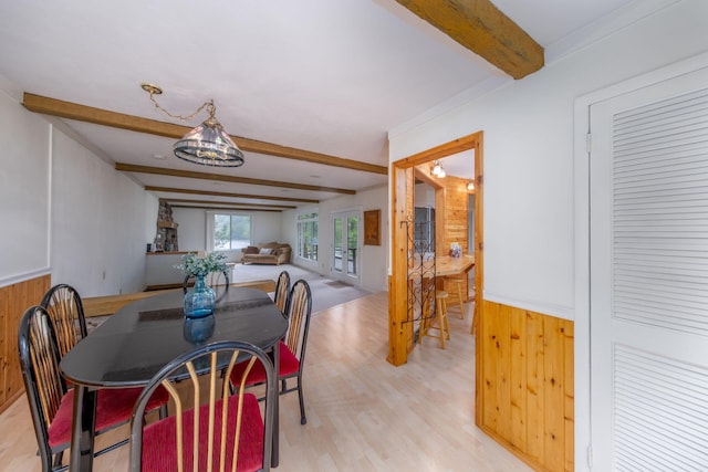 11290 Alpine Rd, Canadian Lakes, MI 49346 - dining space with beam ceiling, wood walls, light wood-style floors, and wainscoting