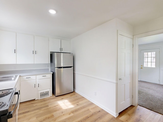 6 Congress Ct Unit D, Saginaw, MI 48602 - kitchen with freestanding refrigerator, range with electric cooktop, white cabinetry, light wood-type flooring, and light countertops