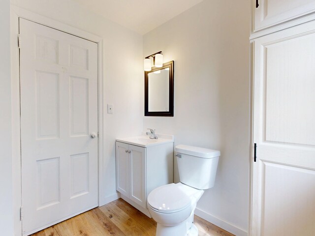 6 Congress Ct Unit D, Saginaw, MI 48602 - half bath featuring wood finished floors, toilet, vanity, and baseboards