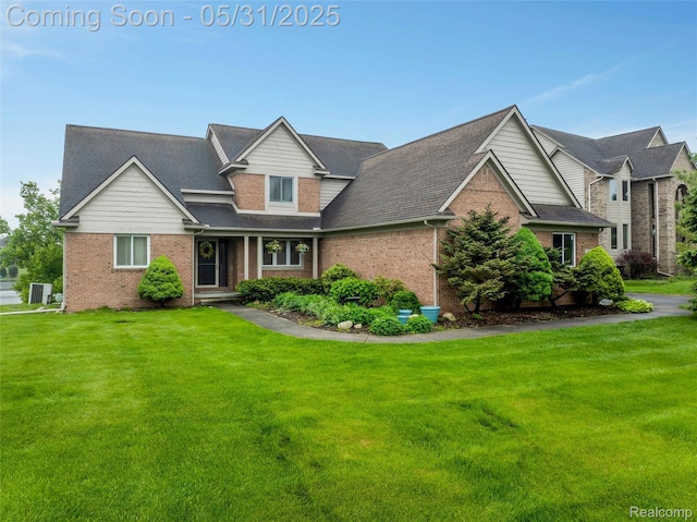4470 Coastal Pkwy, White Lake, MI 48386 - traditional-style home featuring brick siding, a front yard, and a shingled roof