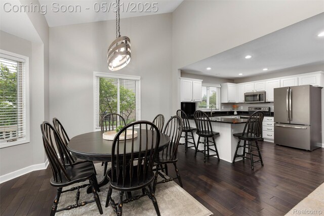 4470 Coastal Pkwy, White Lake, MI 48386 - dining space featuring dark wood-style floors, baseboards, recessed lighting, and a towering ceiling