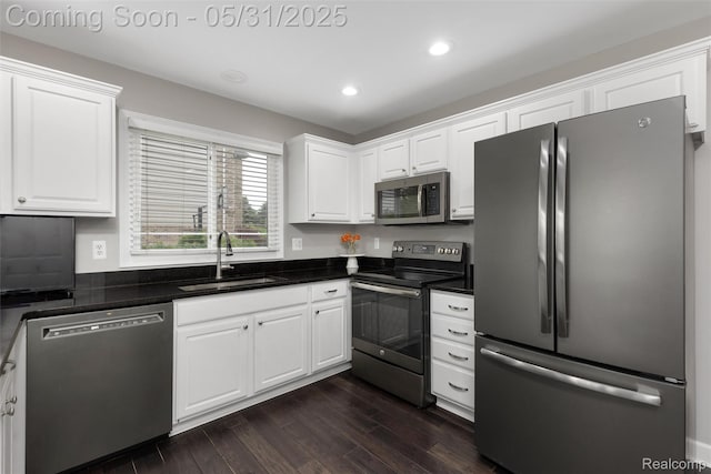 4470 Coastal Pkwy, White Lake, MI 48386 - kitchen featuring stainless steel appliances, a sink, white cabinets, dark wood-type flooring, and recessed lighting