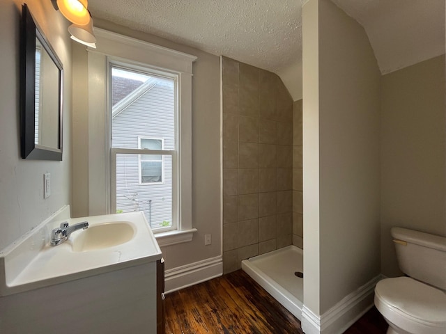 611 New Ave SW, Grand Rapids, MI 49503 - full bathroom featuring toilet, a tile shower, vanity, wood finished floors, and plenty of natural light