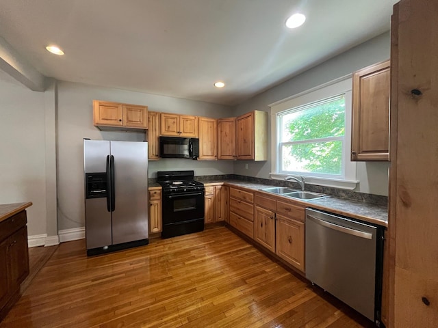611 New Ave SW, Grand Rapids, MI 49503 - kitchen featuring black appliances, a sink, hardwood / wood-style flooring, dark countertops, and recessed lighting