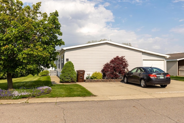 305 Oak Ridge St, Mason, MI 48854 - view of side of property featuring a yard, concrete driveway, and a garage
