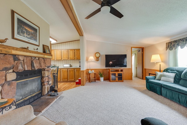 305 Oak Ridge St, Mason, MI 48854 - living room featuring wainscoting, lofted ceiling, a ceiling fan, and a stone fireplace