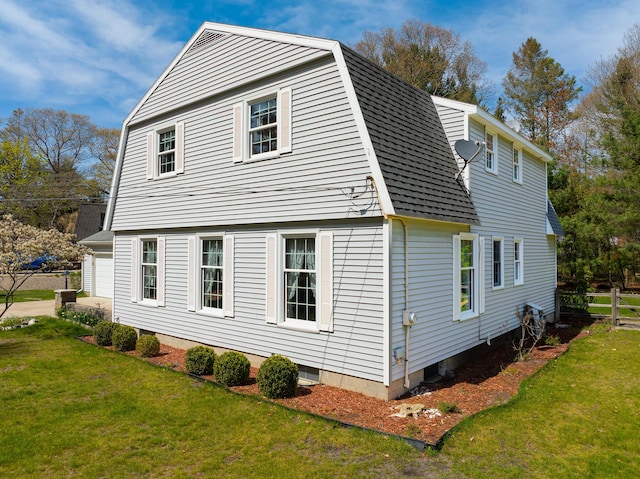 view of side of property featuring a gambrel roof and roof with shingles