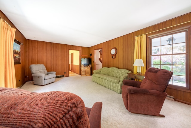 living room featuring light colored carpet, wood walls, and baseboard heating