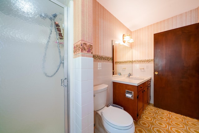 full bathroom with wallpapered walls, a stall shower, tile walls, toilet, and a wainscoted wall